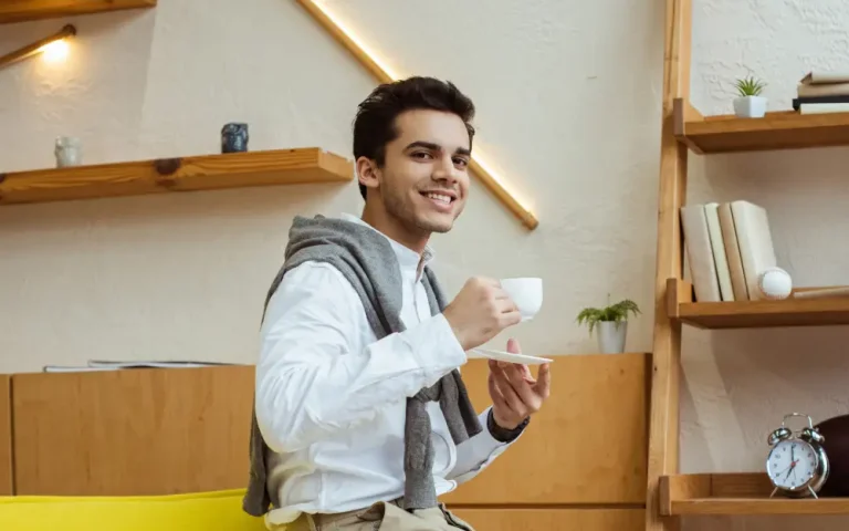 businessman-with-cup-of-coffee-smiling-and-looking-2024-11-08-07-21-31-utc (1)
